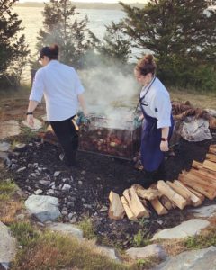 Picture of Chef Casey and Abby carrying clambake