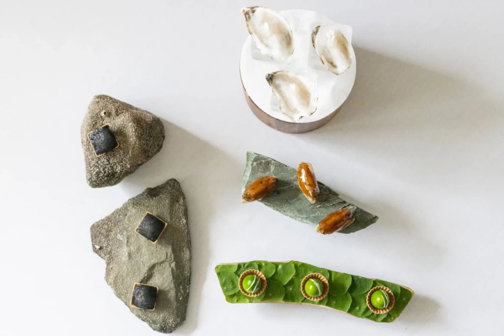 Artfully arranged appetizers on stones and small serving plates.