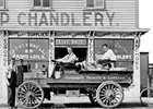Historic photo of a vehicle with wooden wheels delivering oil