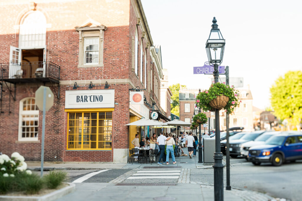 Exterior of Bar Chino with patio seating on a cobblestone street corner near a lamp post.