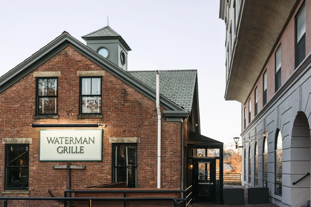 Exterior view of a red brick building with a sign that reads Waterman Grille.
