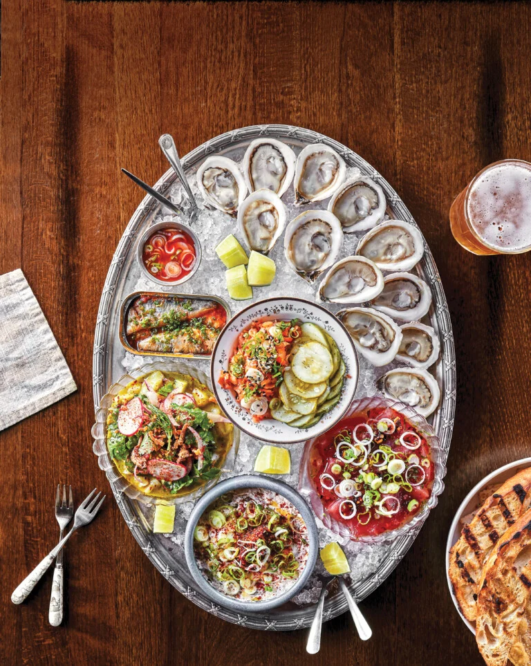 A large platter of oysters and various accompaniment over ice