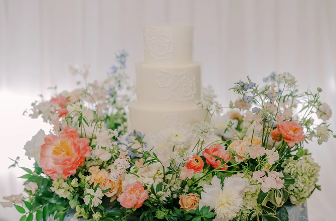 Wedding cake surrounded by fresh flowers